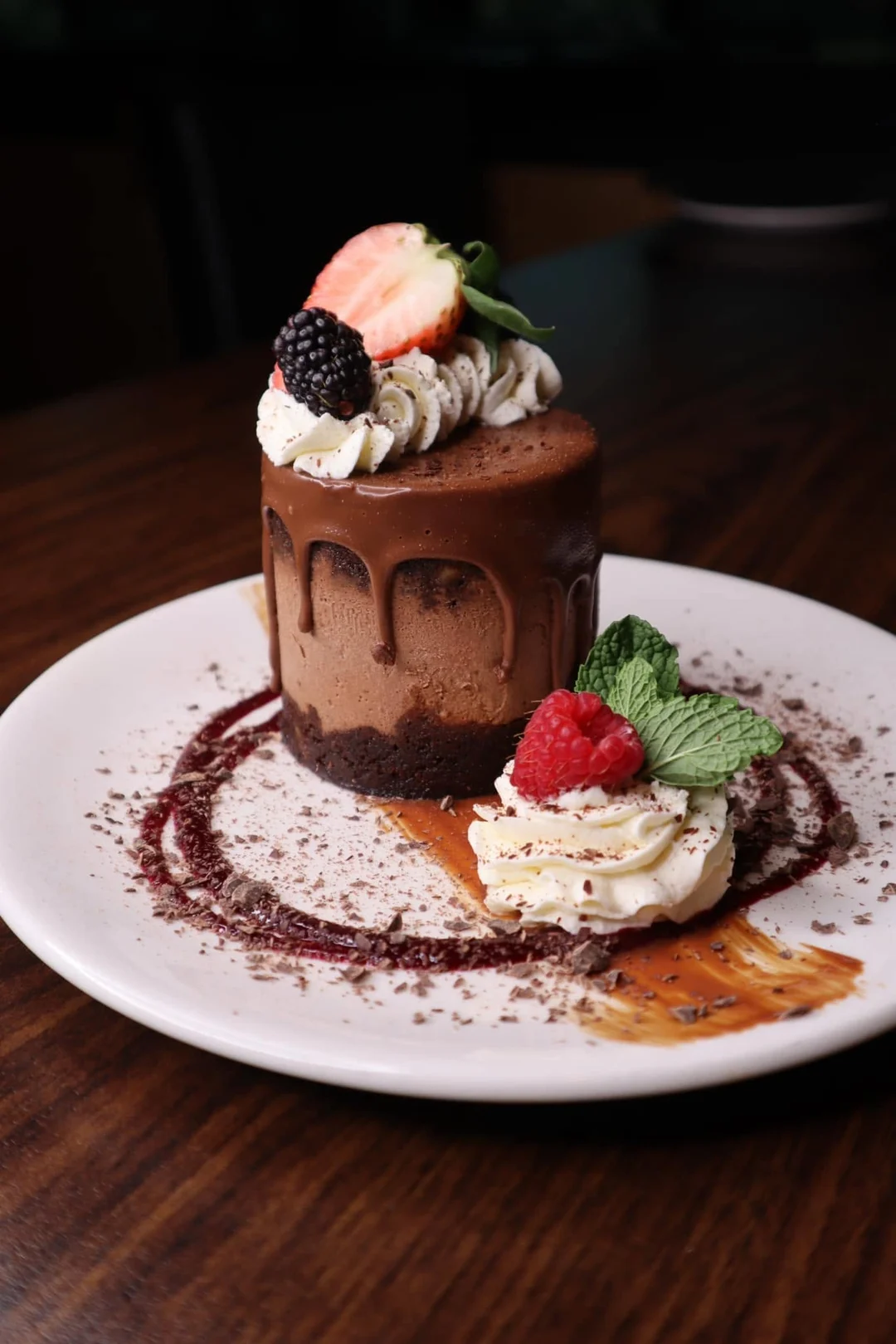 Chocolate mousse cake with berries, whipped cream and a raspberry coulis, plated at Prime 88